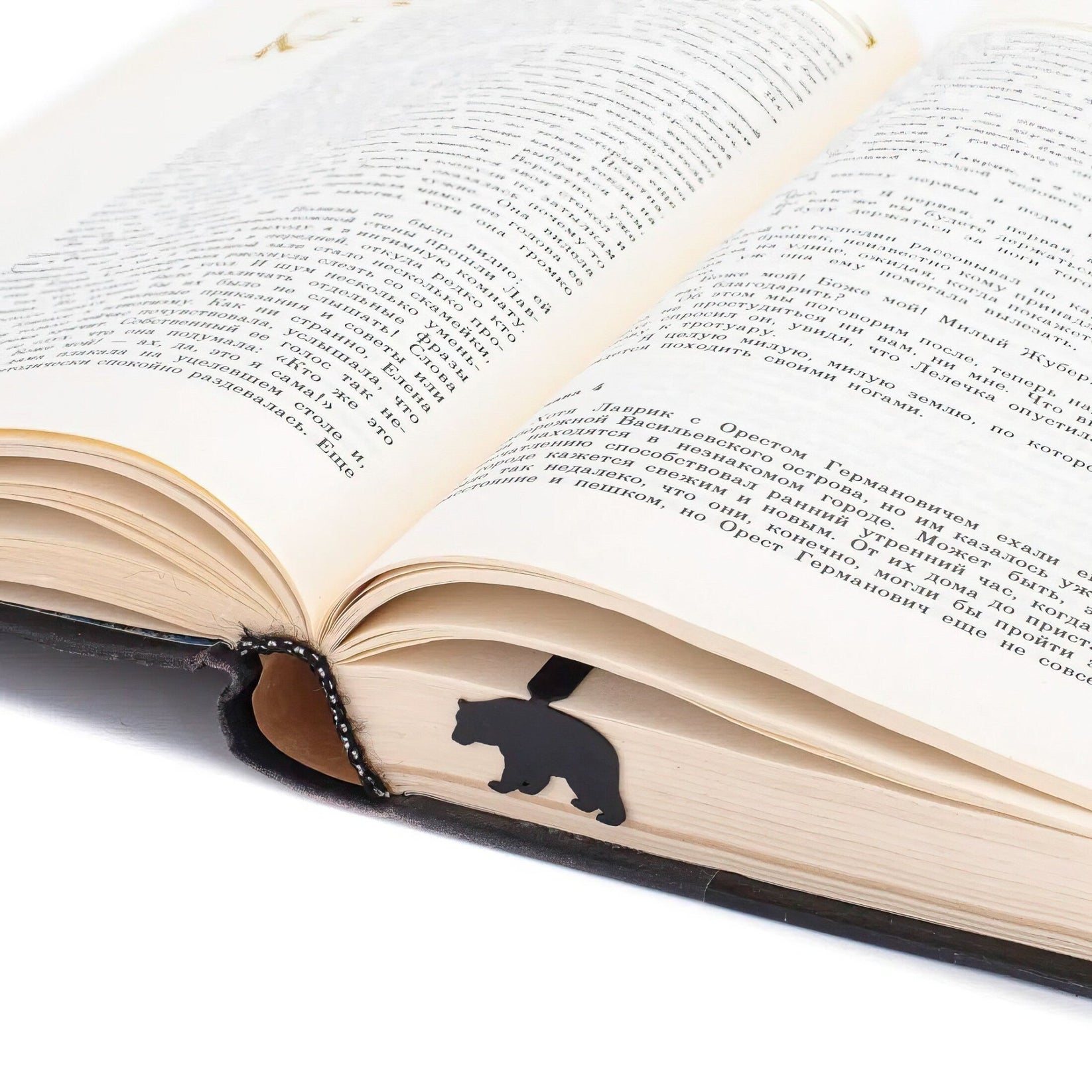 Bear metal bookmark marking a page in an open book