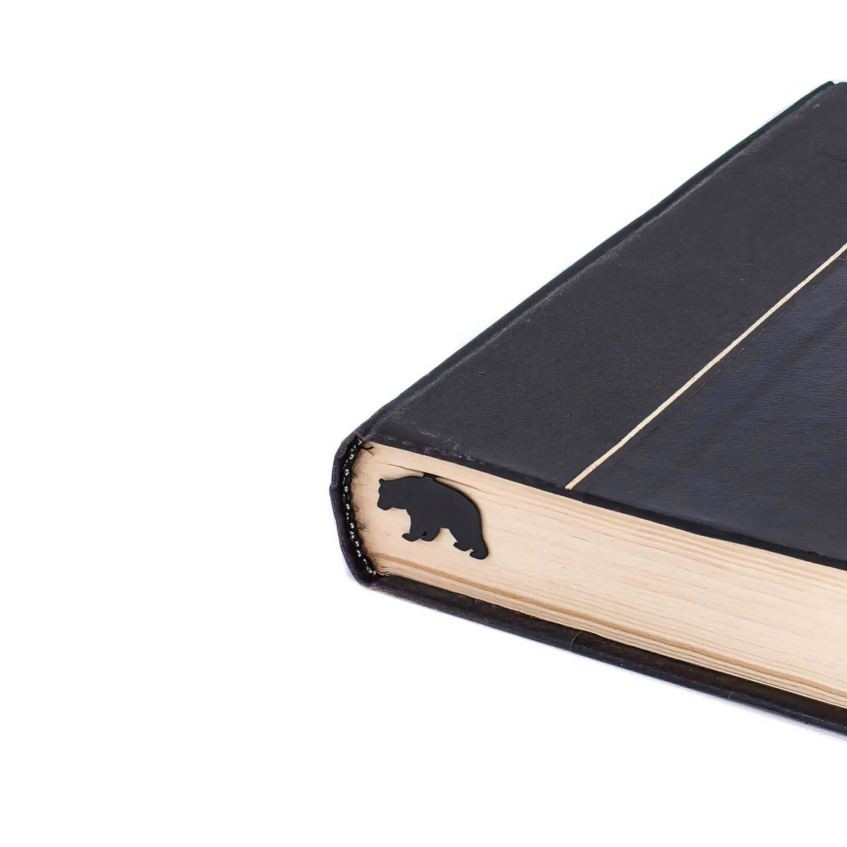 Bear metal bookmark in a closed book, only its top showing above the pages