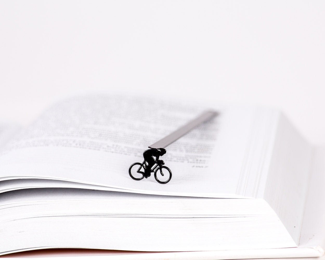 Bike Racing metal bookmark resting on the pages of an open book