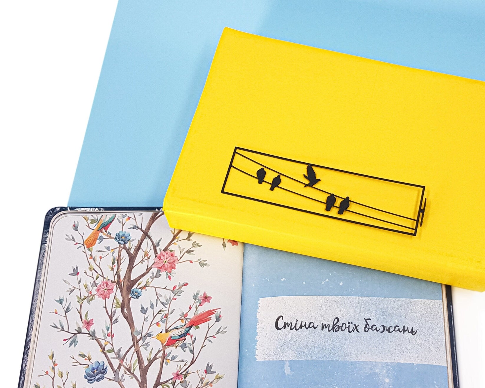 Birds on the Wire metal bookmark on a coloured background