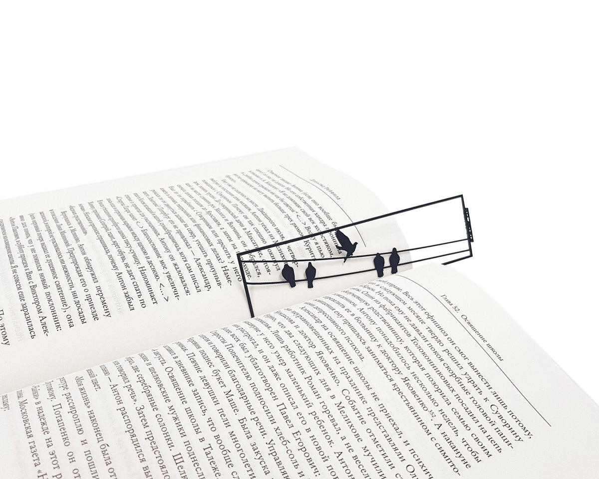 Birds on the Wire metal bookmark marking a page in an open book