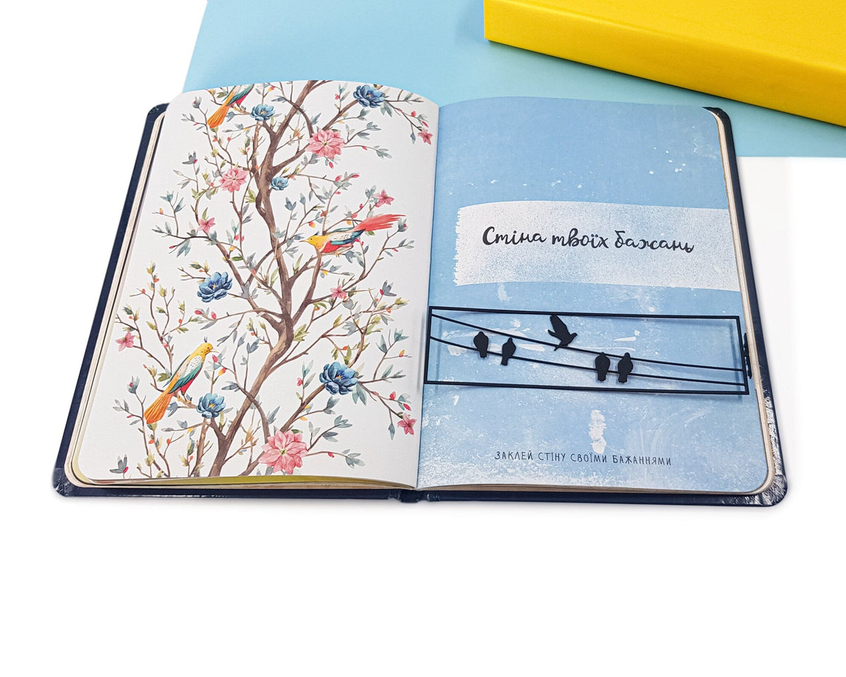 Birds on the Wire metal bookmark marking a page in a notebook