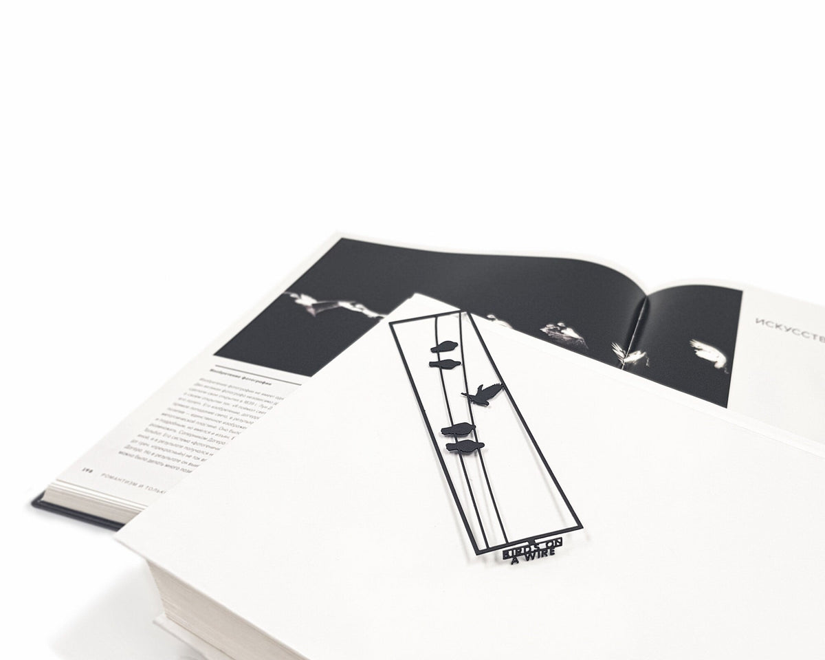 Birds on the Wire metal bookmark on an illustrated page