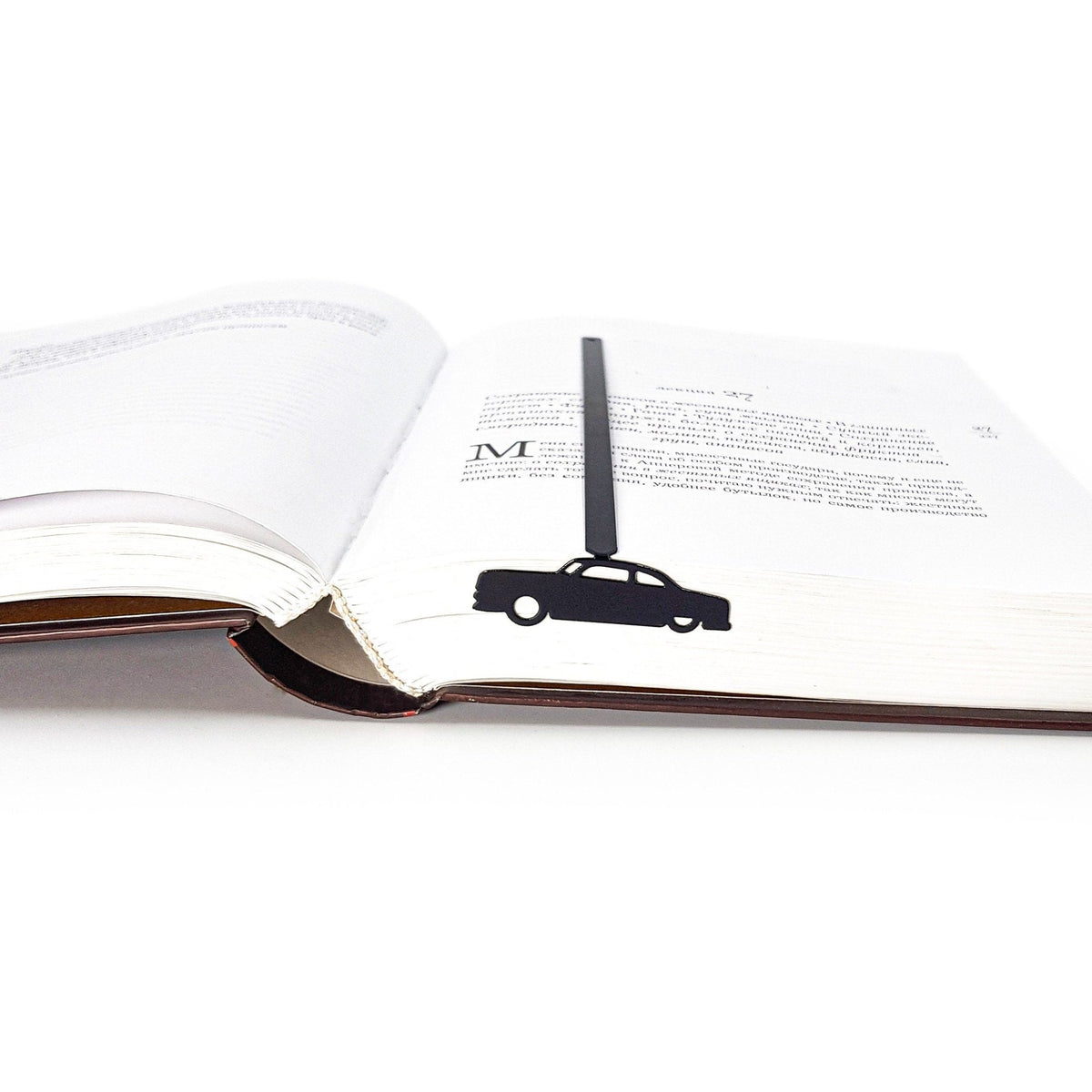 Black Car Phantom metal bookmark marking a page in an open book
