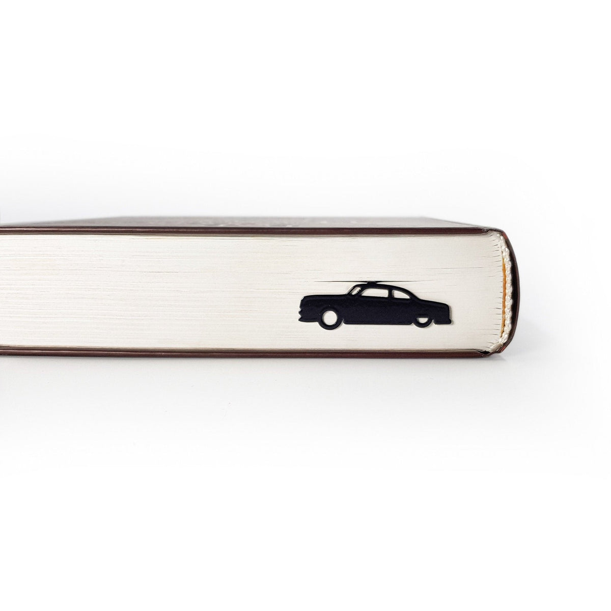 Black Car Phantom metal bookmark seen from the edge of a closed book
