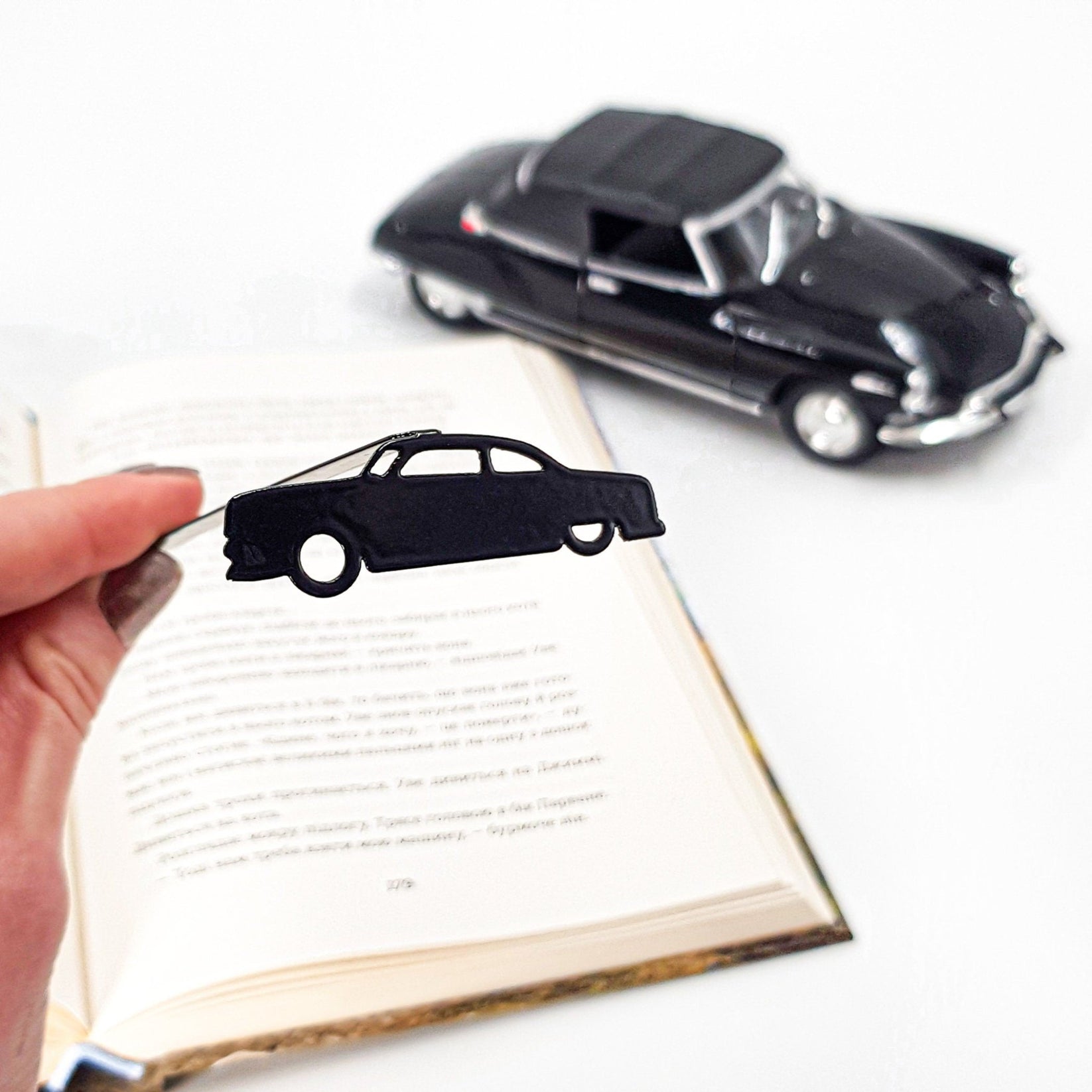 Black Car Phantom metal bookmark — beside a toy model car