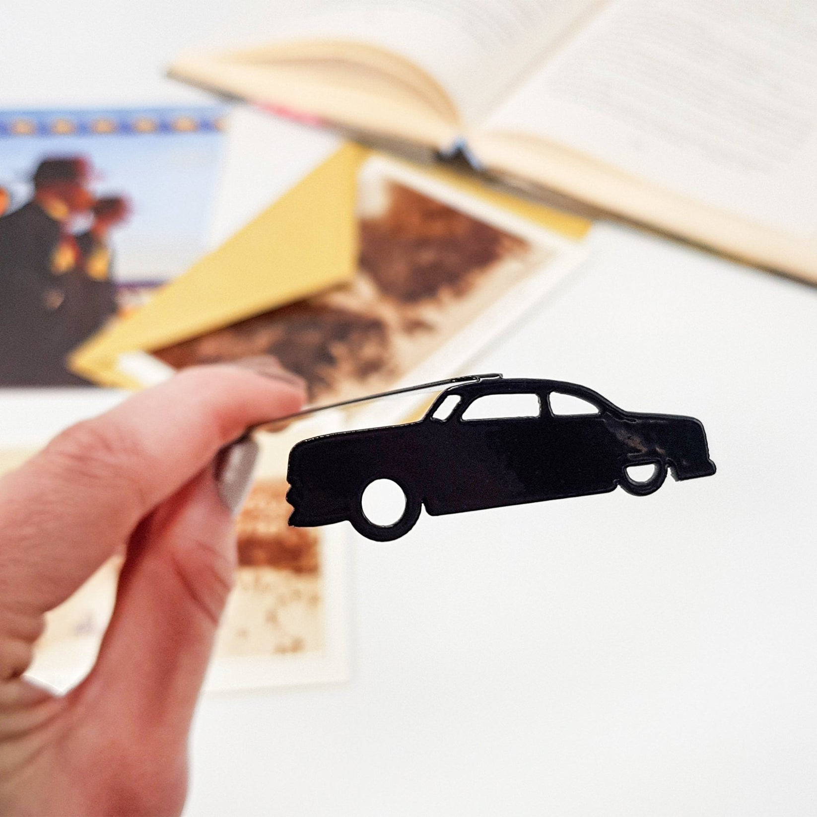 Black Car Phantom metal bookmark marking a page in an illustrated book