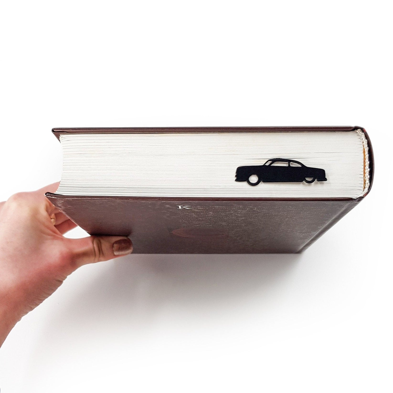 Black Car Phantom metal bookmark in a closed book, only its top showing above the pages