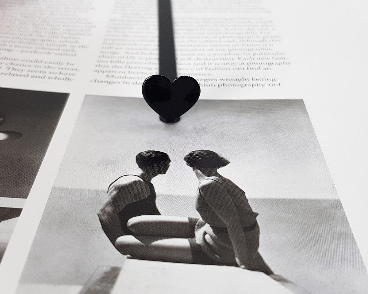 Black Heart metal bookmark marking a page in an illustrated book