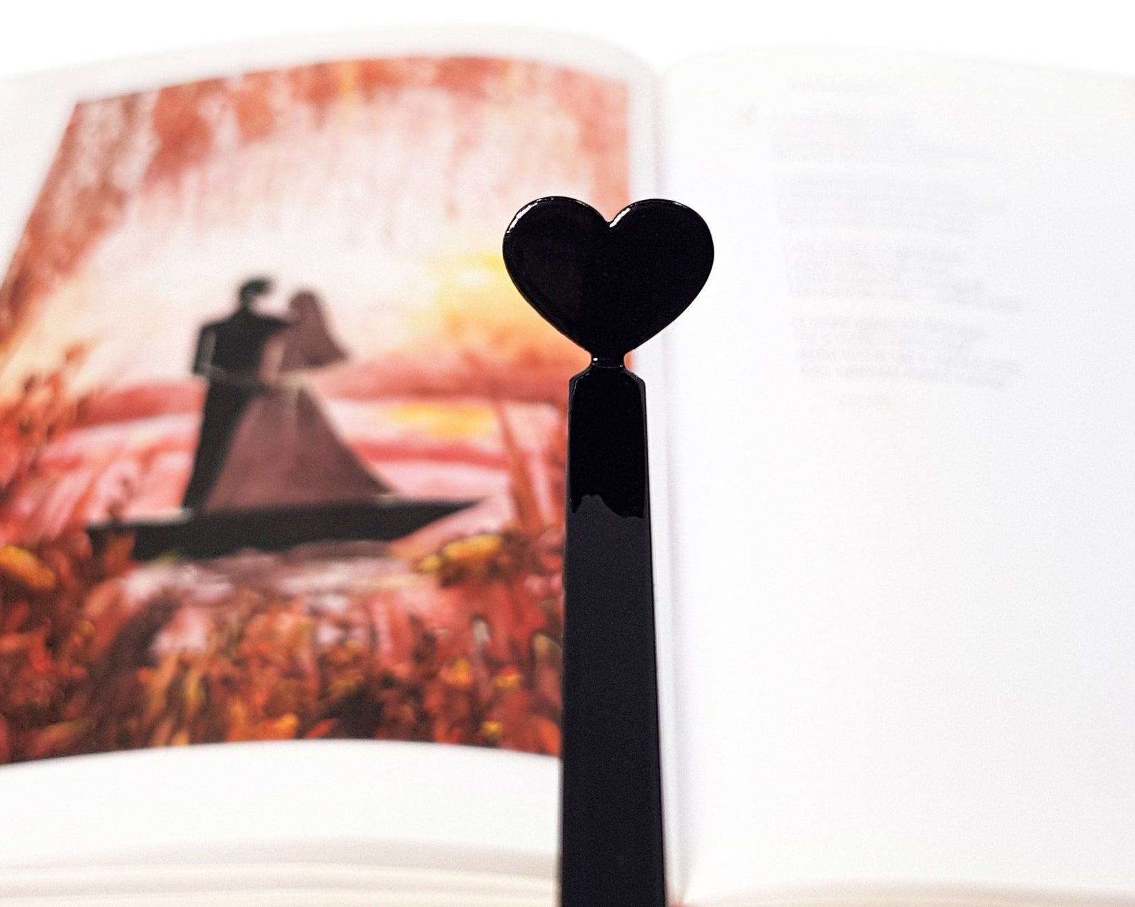 Black Heart metal bookmark placed on a colour illustration