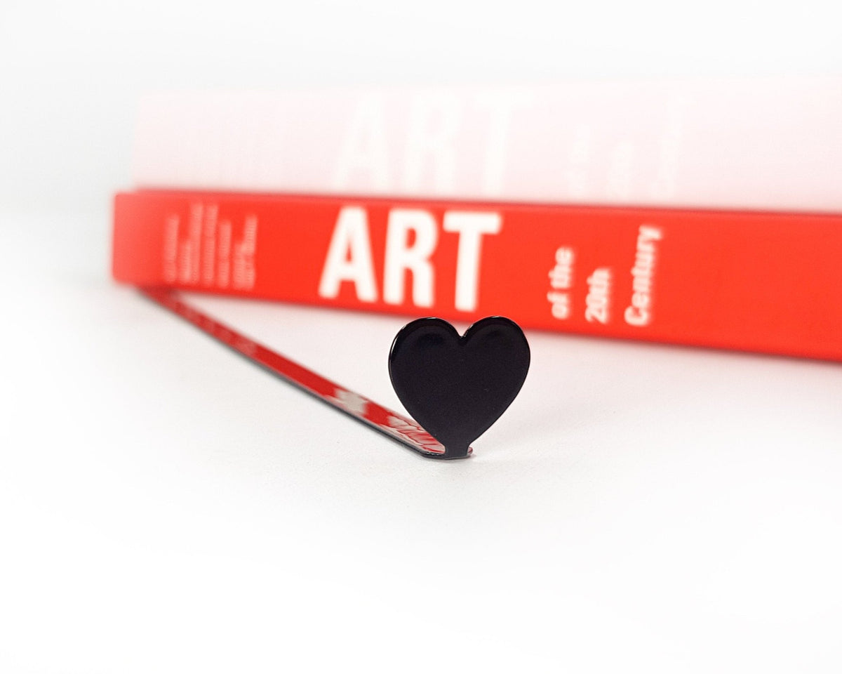 Black Heart metal bookmark seen from the edge of a closed book