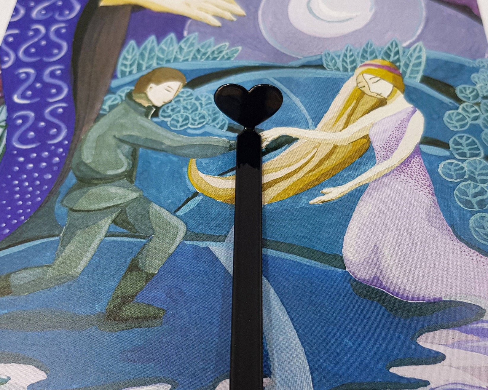 Black Heart metal bookmark on an illustrated page