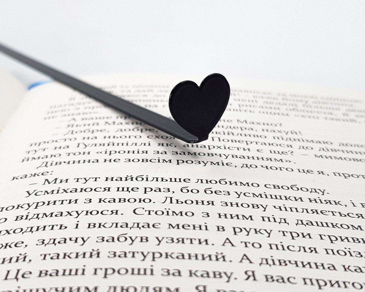 Black Heart metal bookmark lying across the pages of an open book