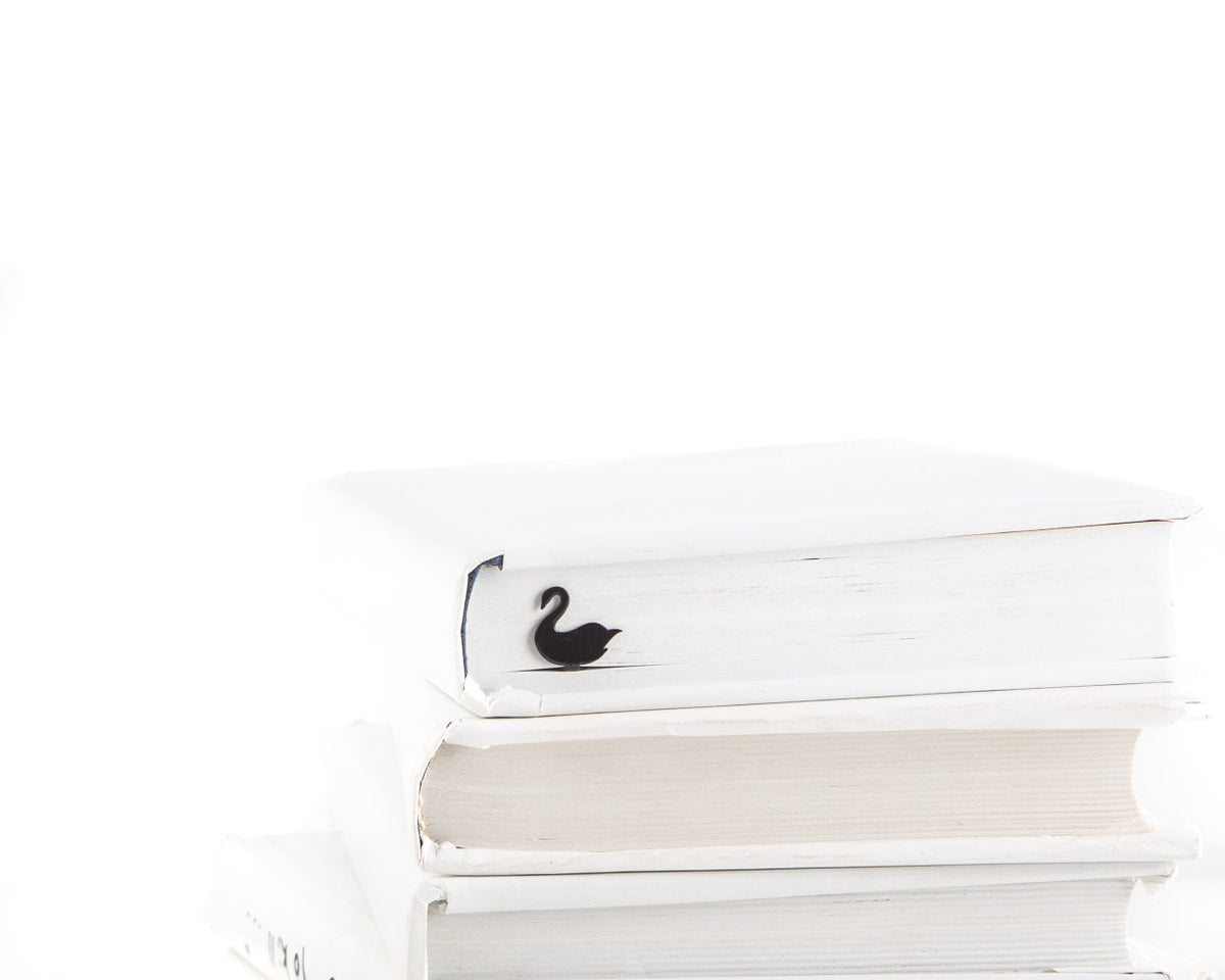 Black Swan metal bookmark shown with a stack of books