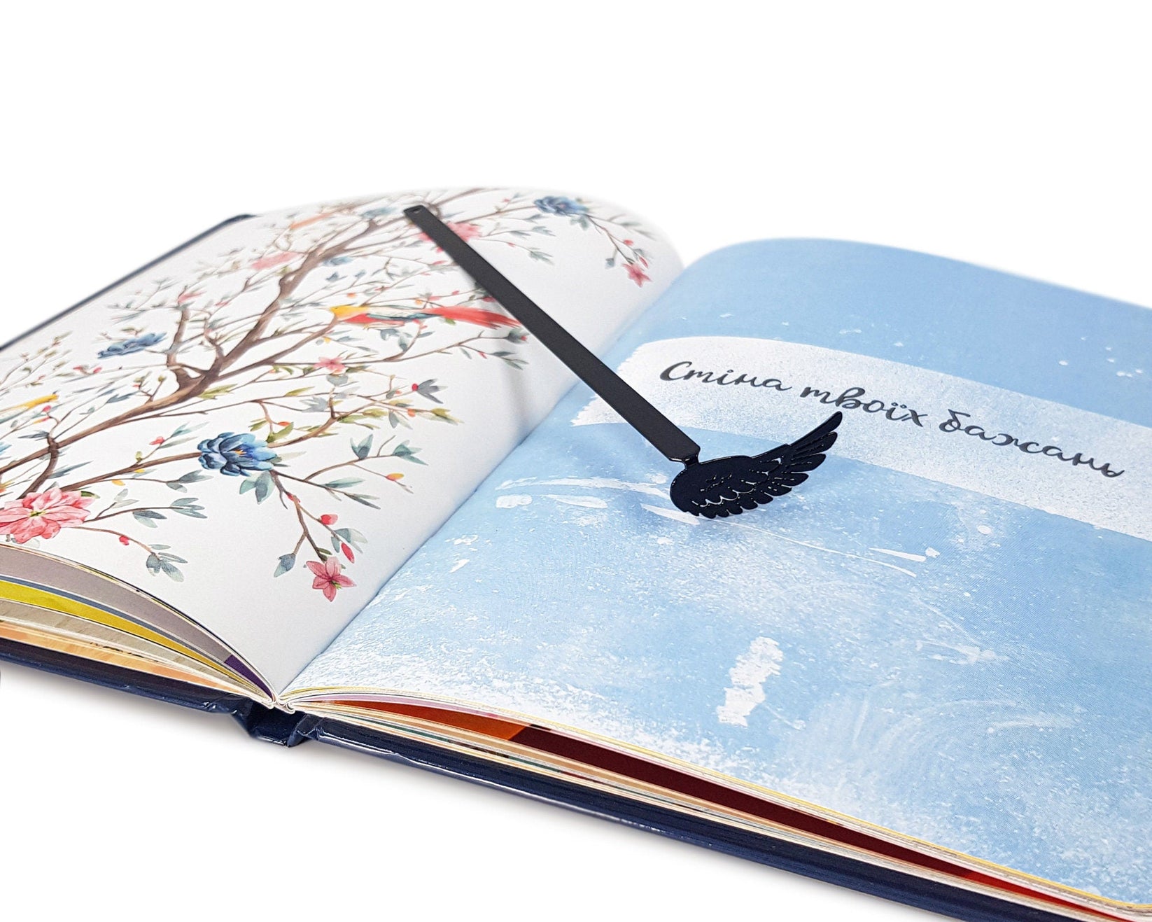 Black Wing metal bookmark on an illustrated page, view 5