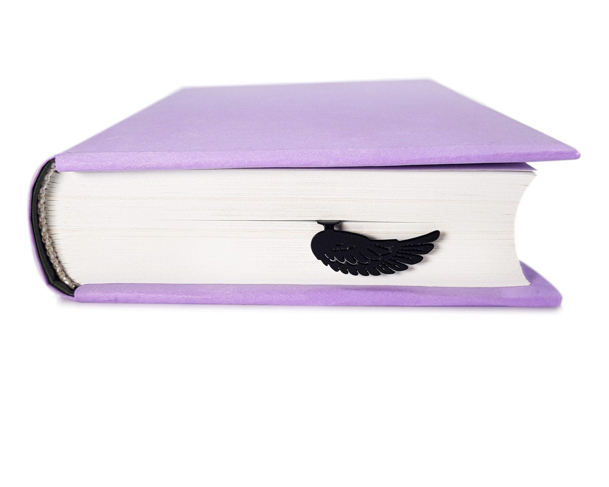 Black Wing metal bookmark in a closed book, only its top showing above the pages