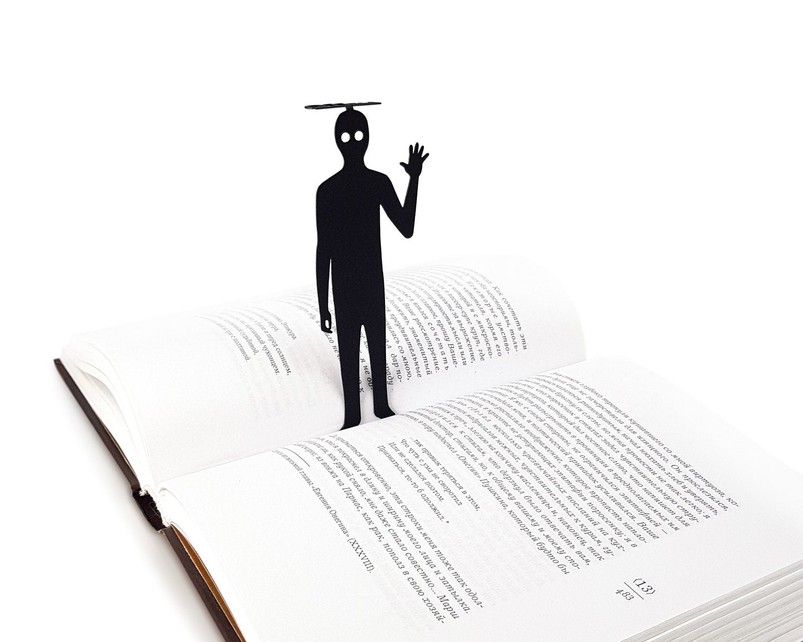 Book Ghost metal bookmark lying across the pages of an open book