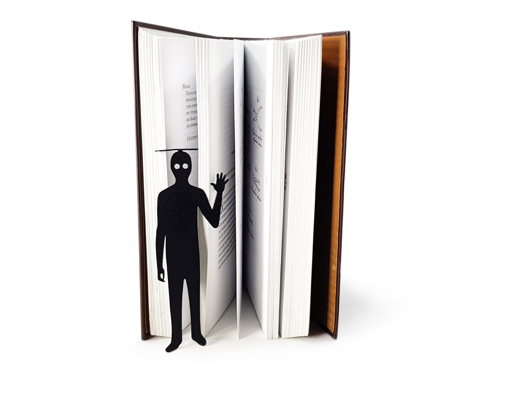 Book Ghost metal bookmark set into the gutter of an open book