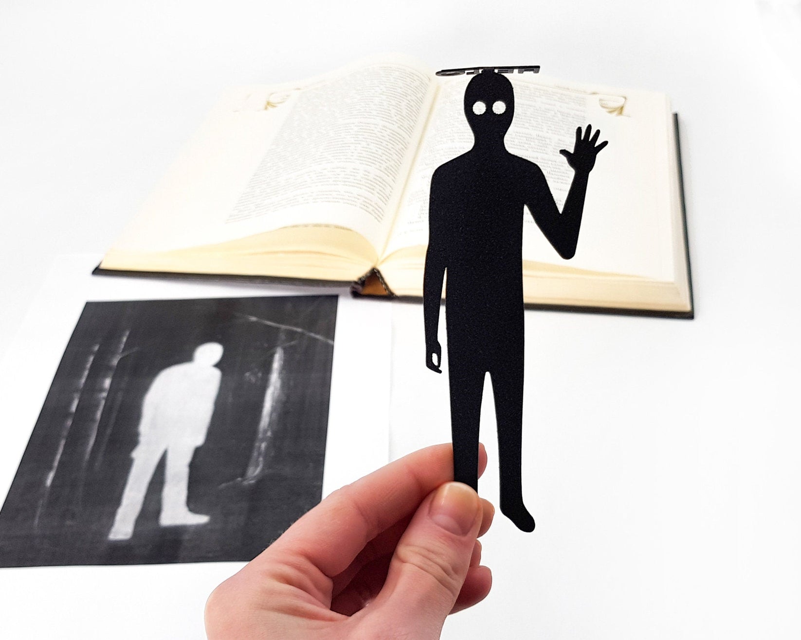 Book Ghost metal bookmark resting on the pages of an open book