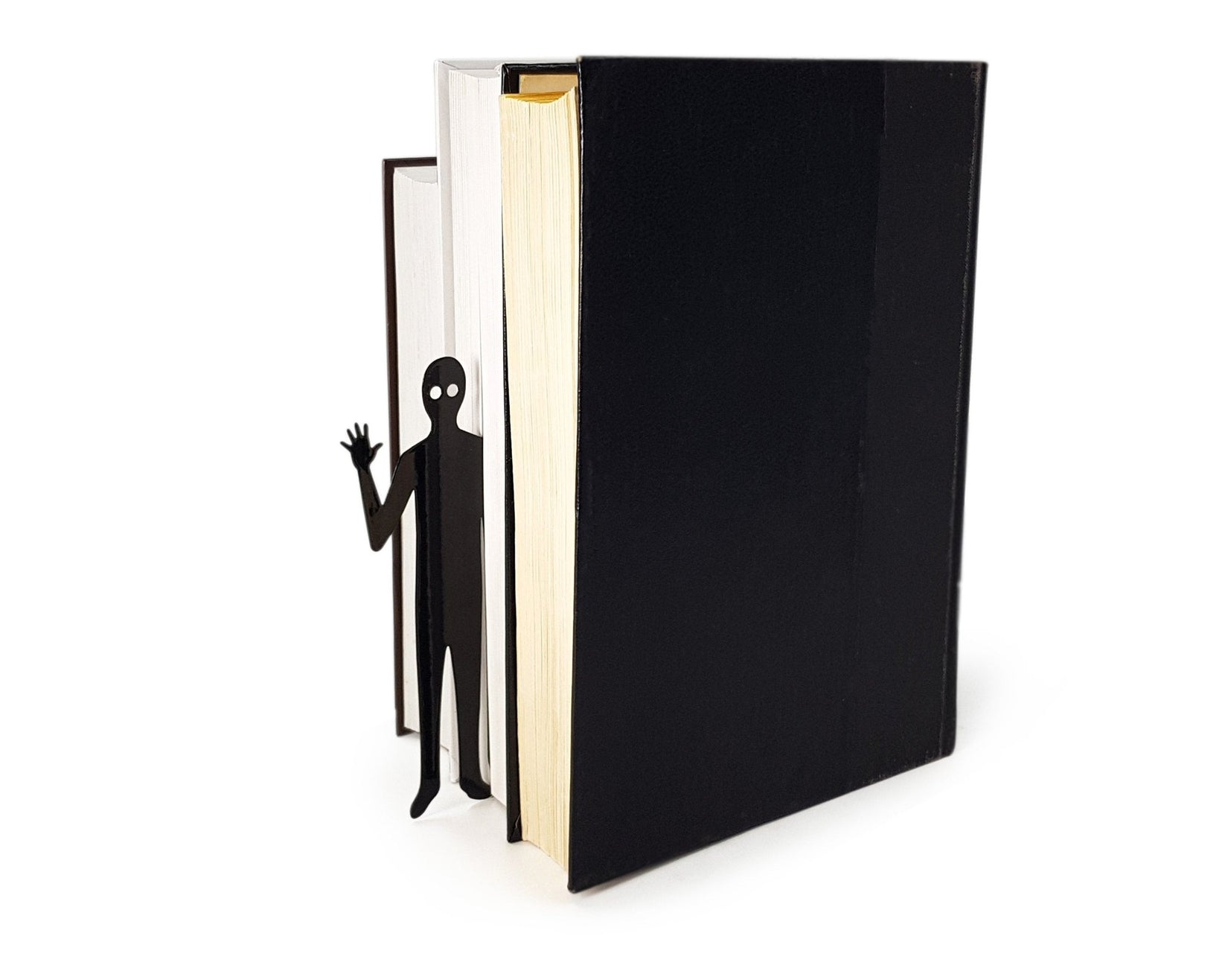 Book Ghost Coming Out metal bookmark seen from the edge of a closed book
