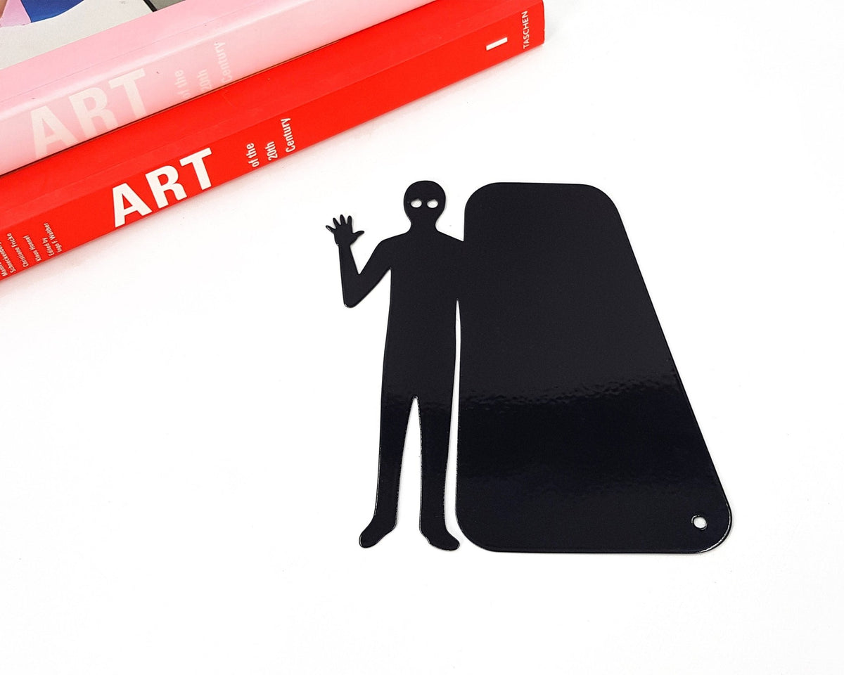 Book Ghost Coming Out metal bookmark clipped in a closed book, viewed from the side