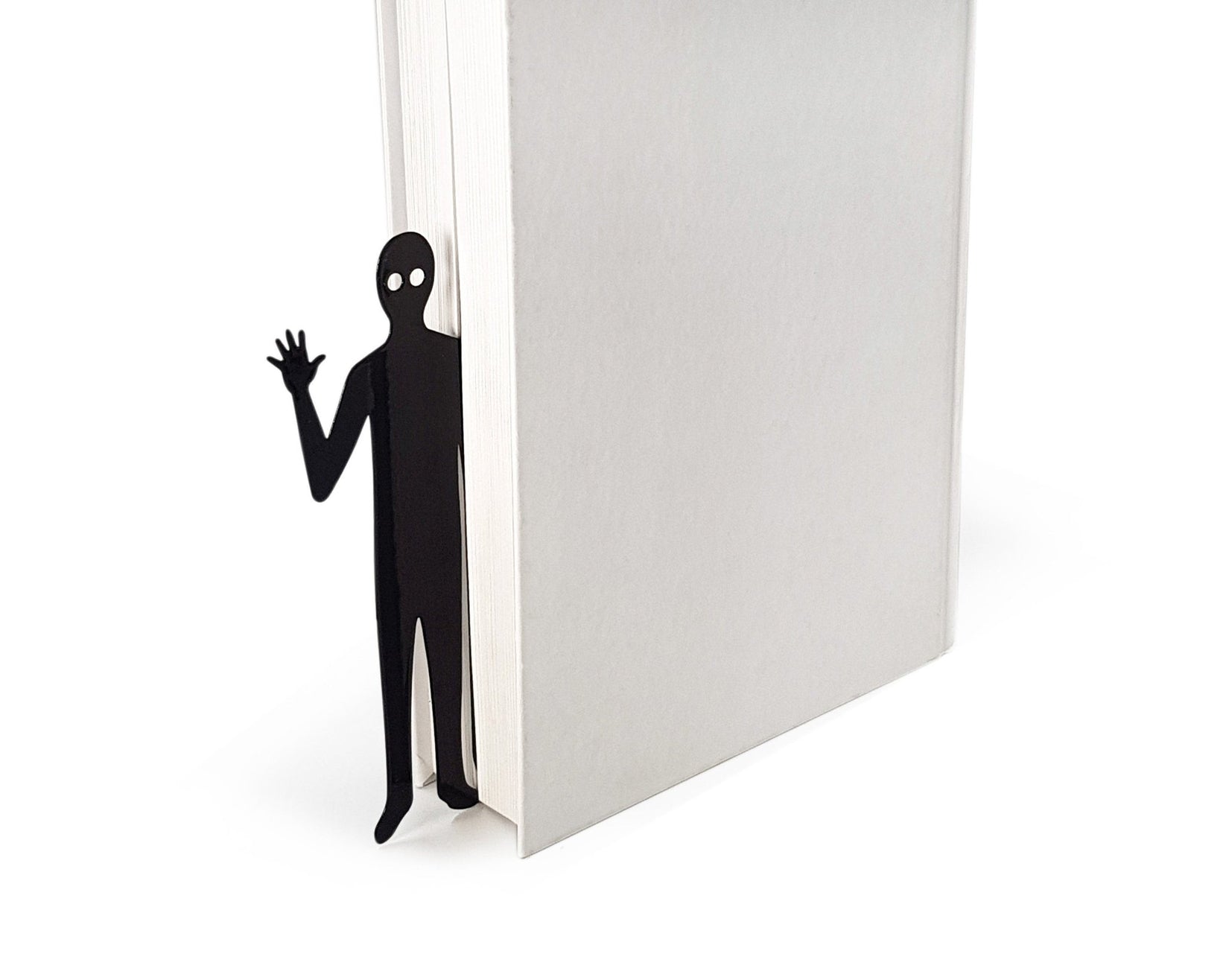 Book Ghost Coming Out metal bookmark in a closed book, only its top showing above the pages