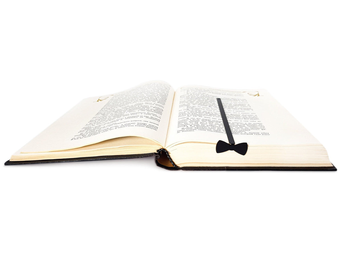 Bow Tie metal bookmark lying across the pages of an open book