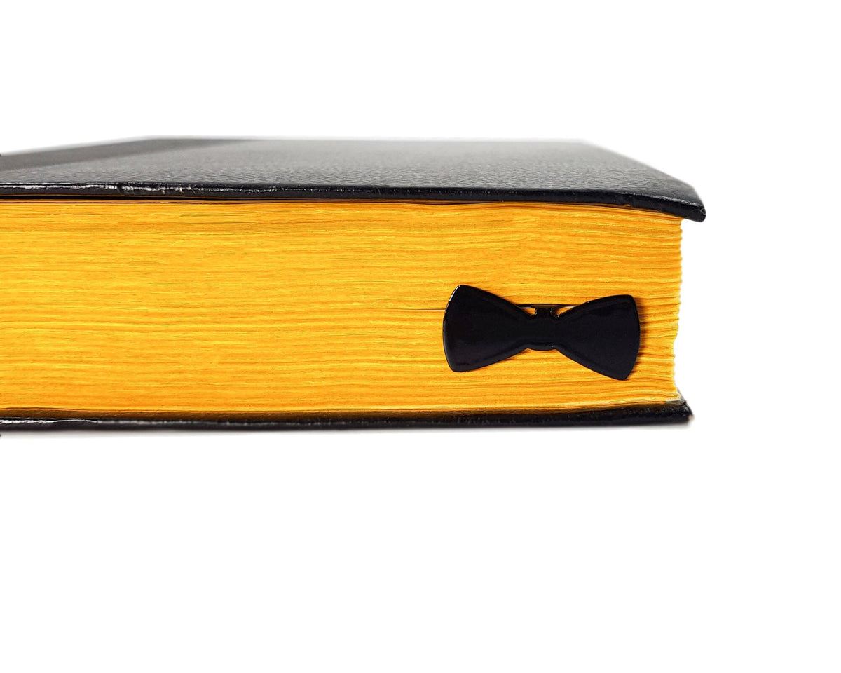 Bow Tie metal bookmark in a closed book, only its top showing above the pages
