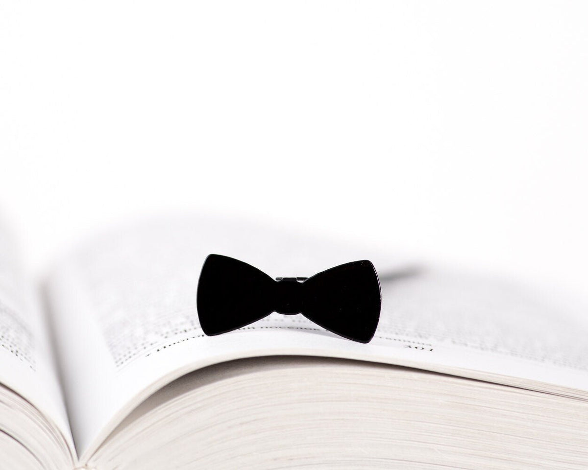 Bow Tie metal bookmark resting on the pages of an open book