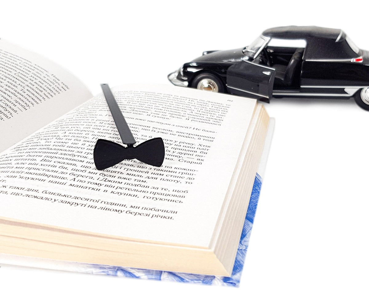 Bow Tie metal bookmark — open book beside black toy car, another view (2)