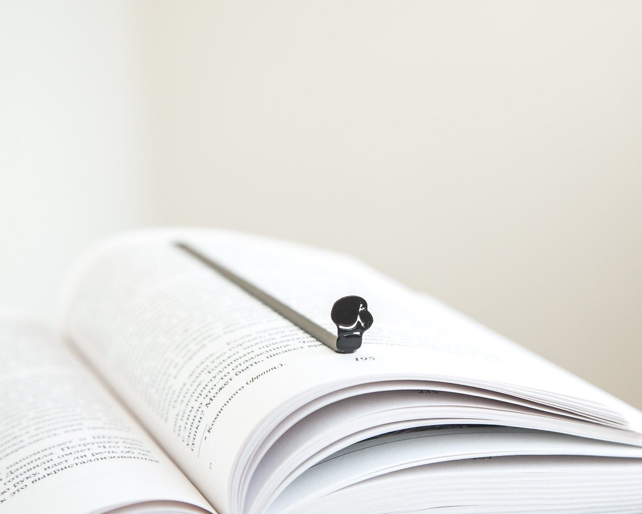 Boxing Glove metal bookmark resting on the pages of an open book