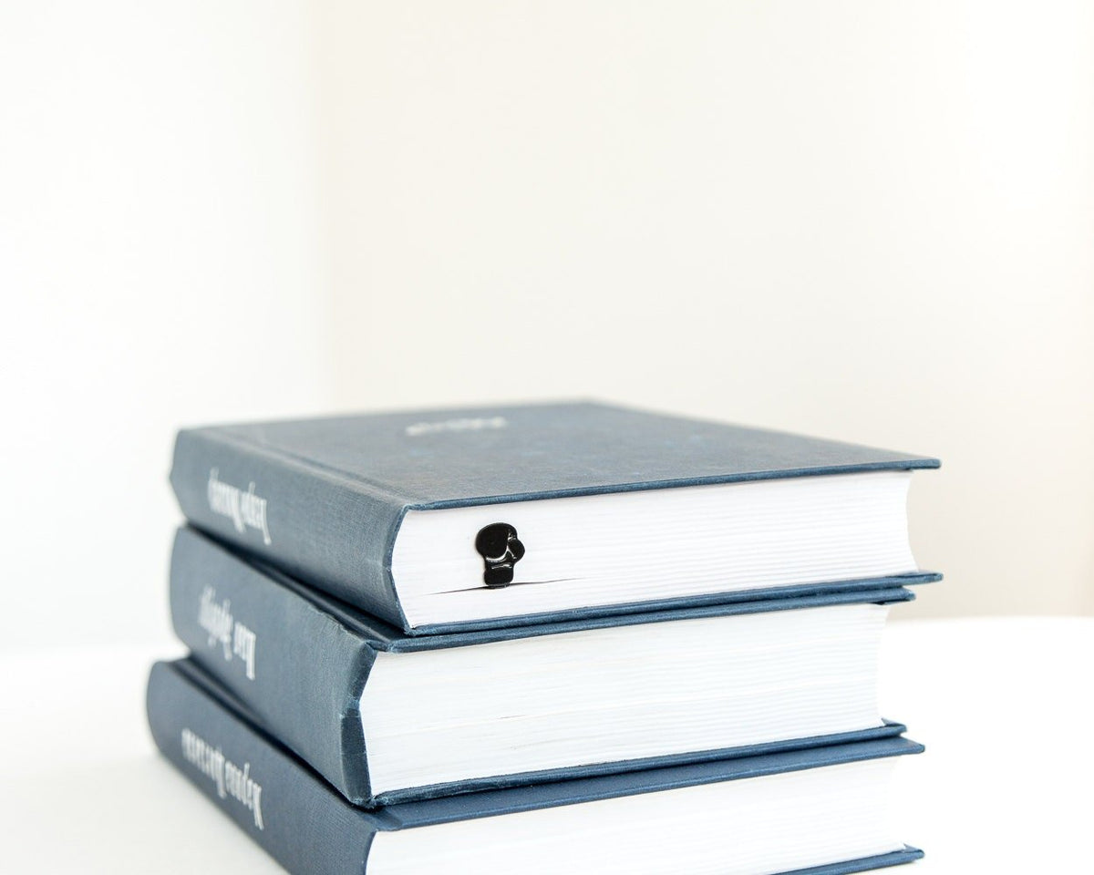 Boxing Glove metal bookmark shown with a stack of books