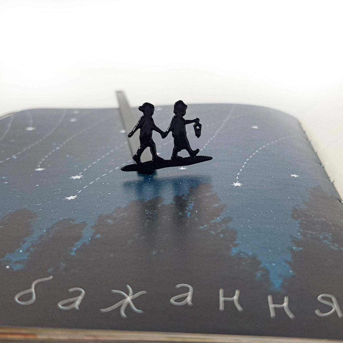 Boy and Girl metal bookmark on a coloured background