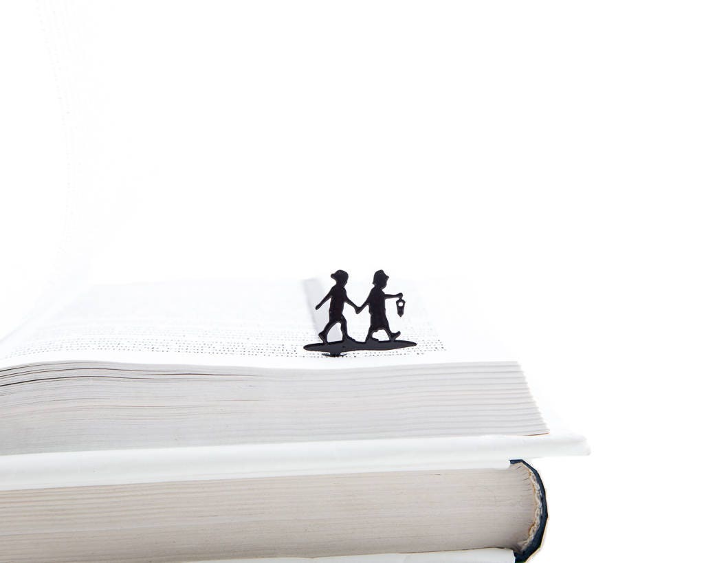 Boy and Girl metal bookmark in a closed book, only its top showing above the pages