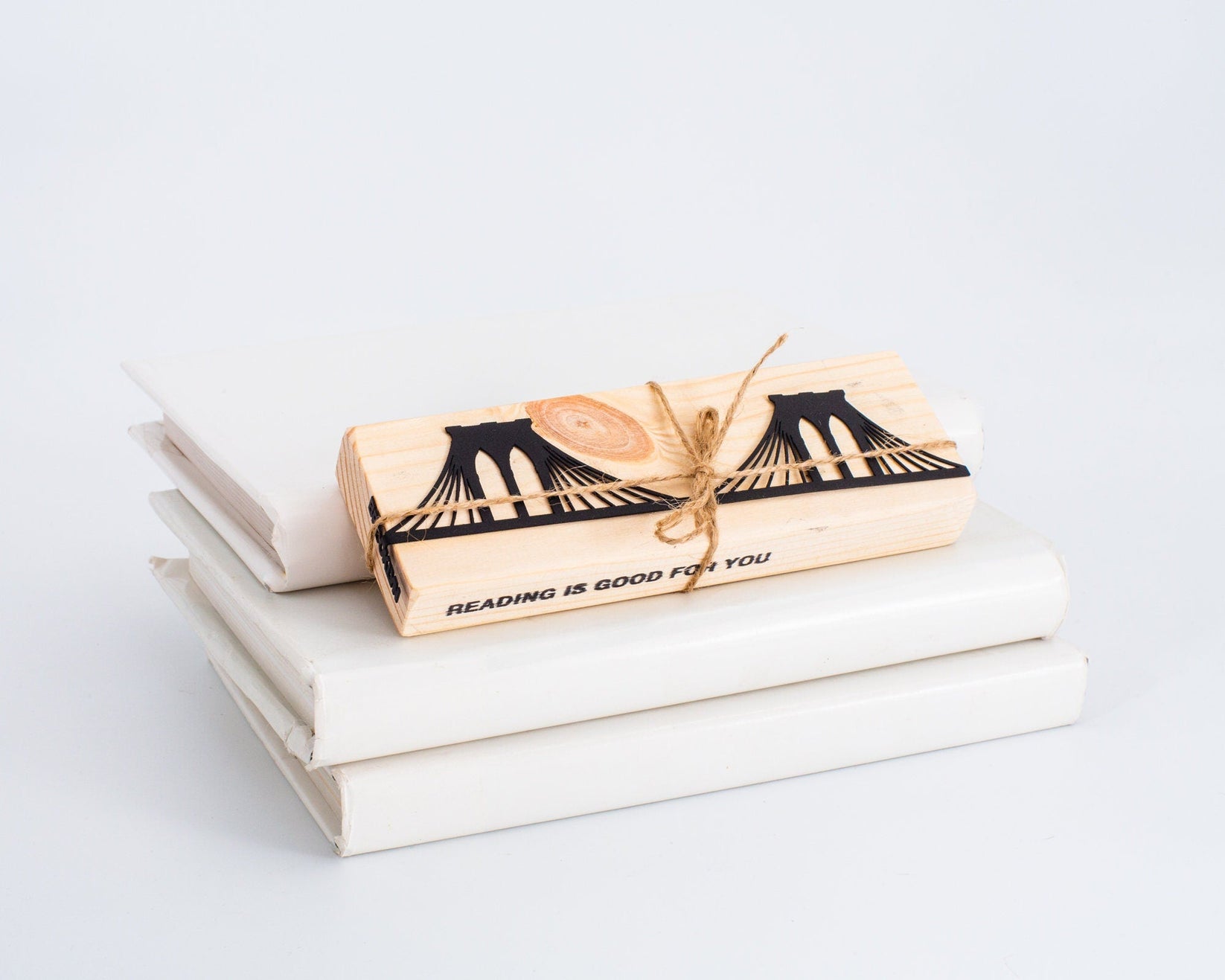 Brooklyn Bridge metal bookmark shown with a stack of books