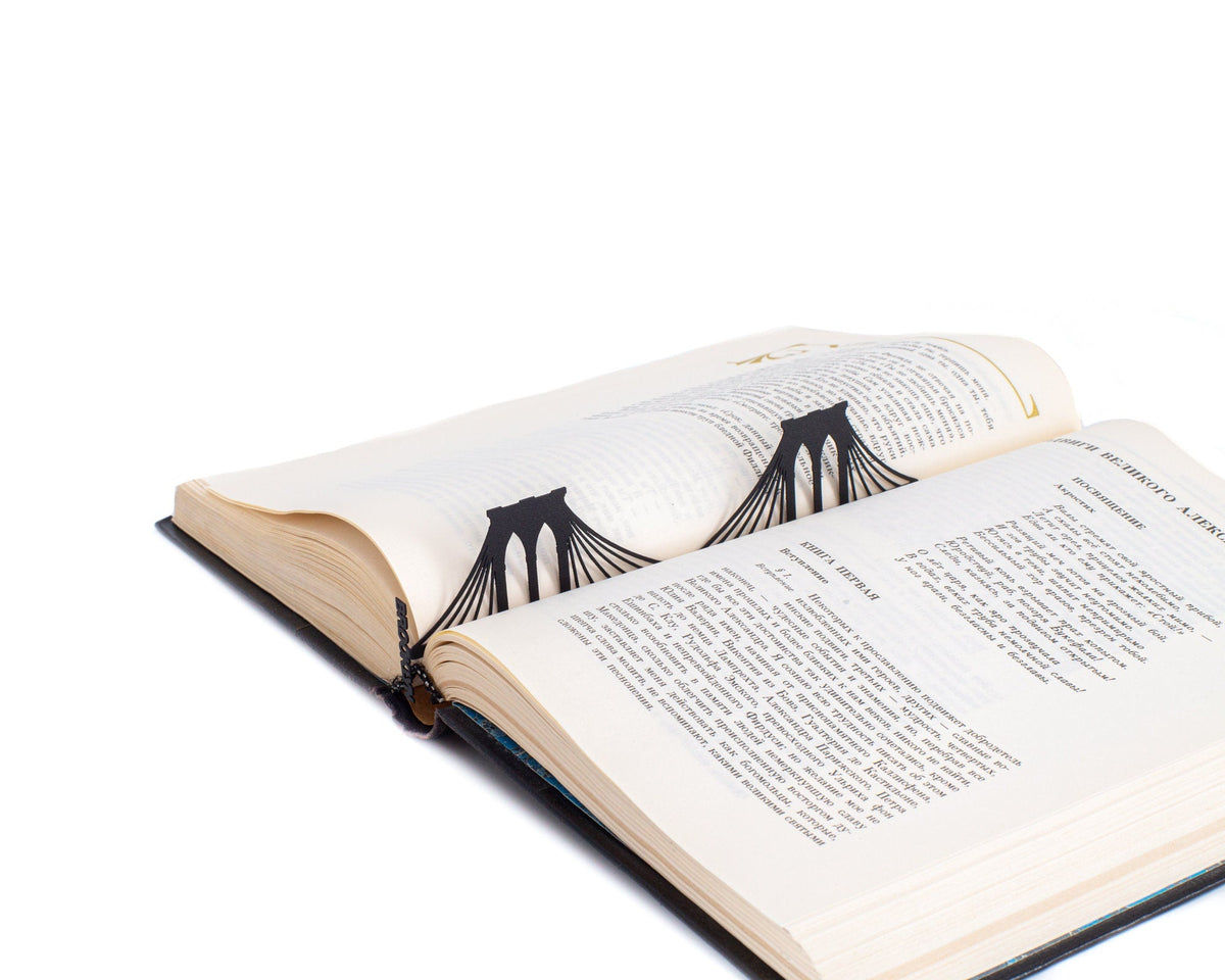 Brooklyn Bridge metal bookmark resting on the pages of an open book