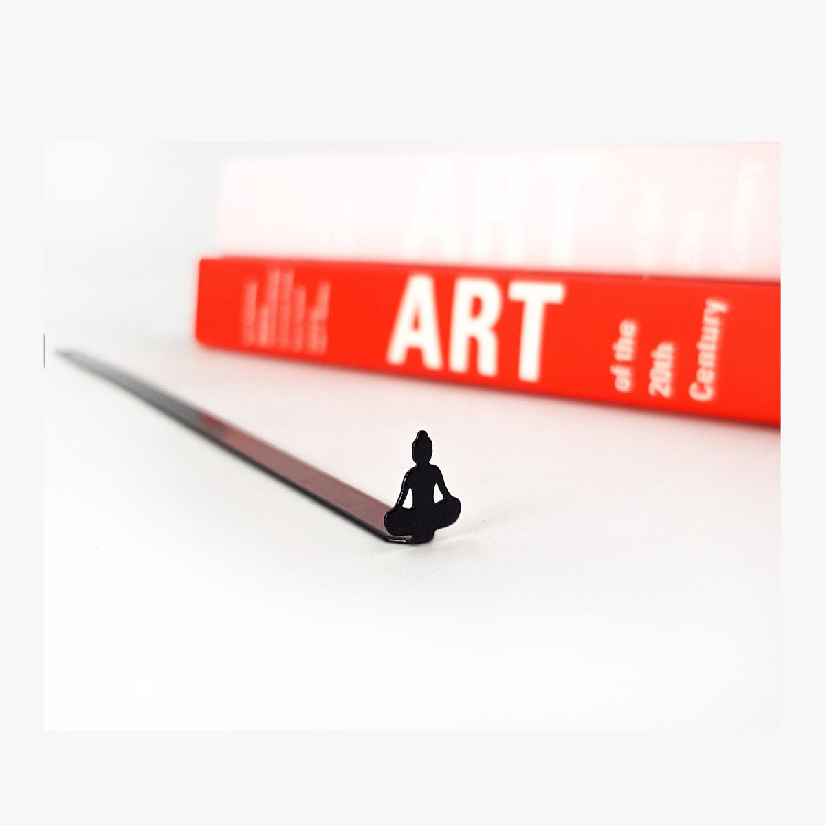 Buddha metal bookmark in a closed book, only its top showing above the pages