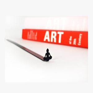 Buddha metal bookmark in a closed book, only its top showing above the pages