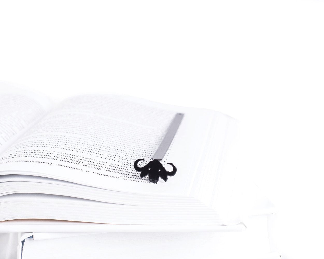 Buffalo metal bookmark marking a page in an open book