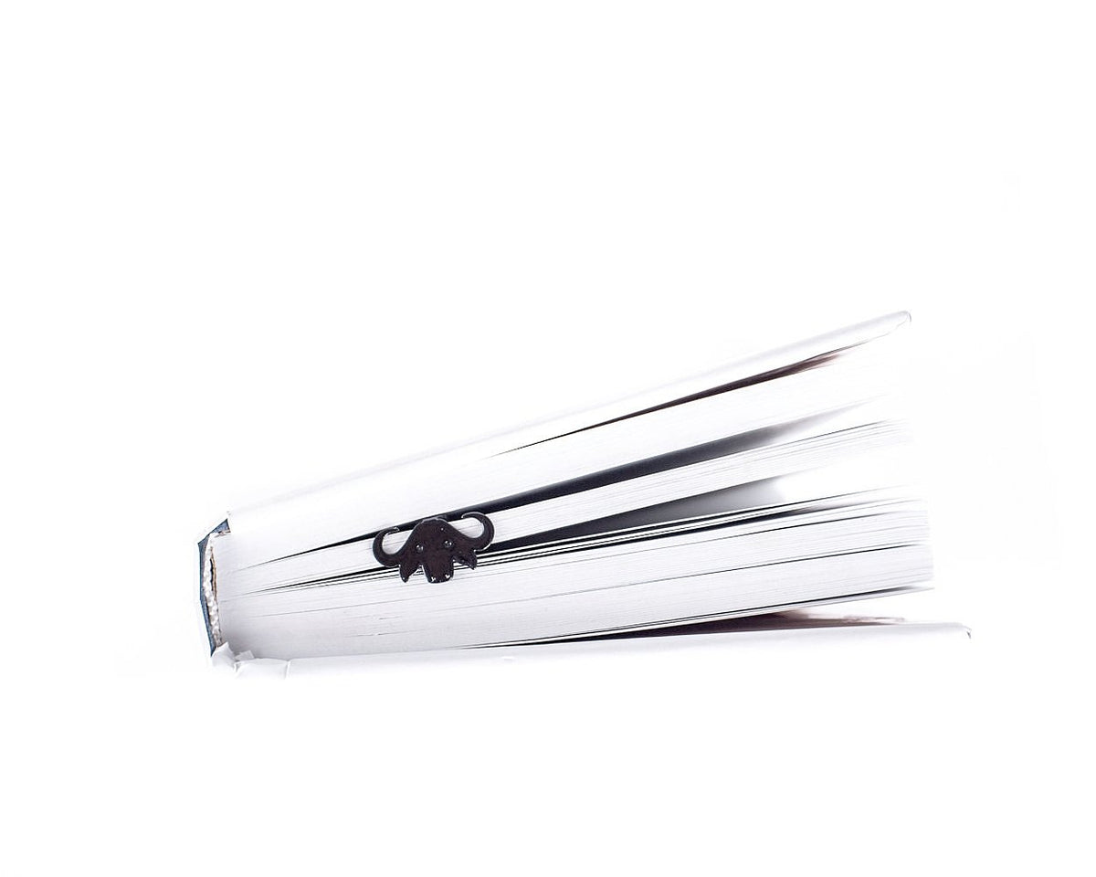 Buffalo metal bookmark resting on the pages of an open book