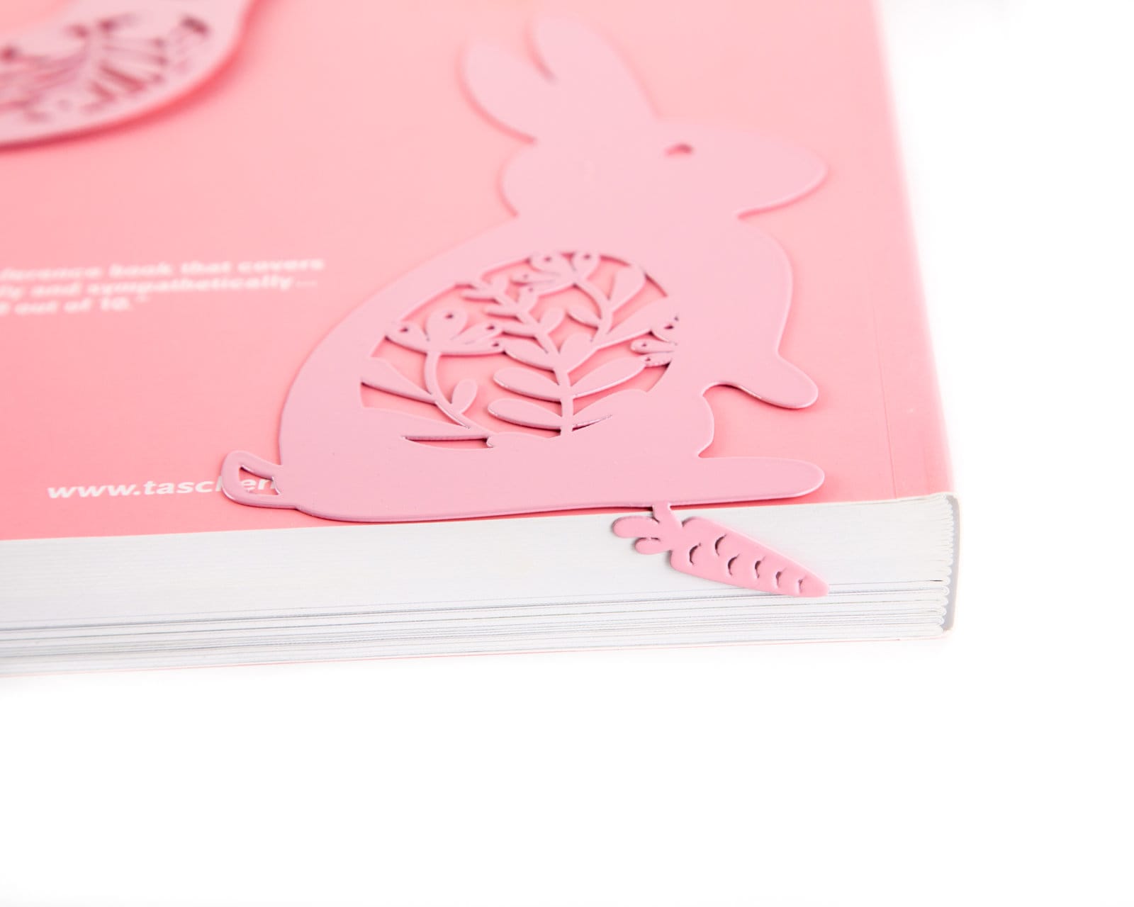Bunny with a Carrot metal bookmark in red in a closed book, only its top showing above the pages