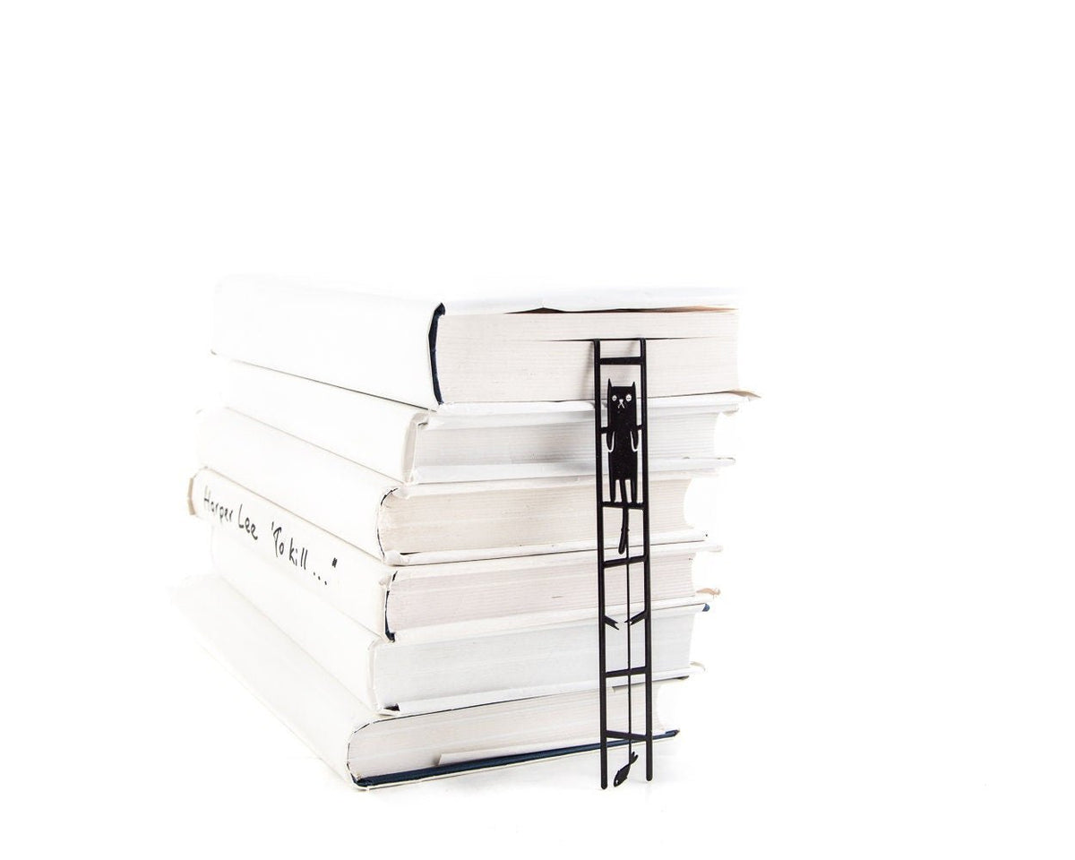 Cat and the Fish metal bookmark shown with a stack of books