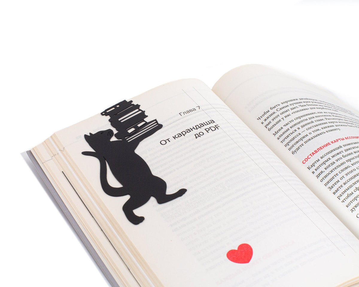 Cat the Librarian metal bookmark resting on the pages of an open book