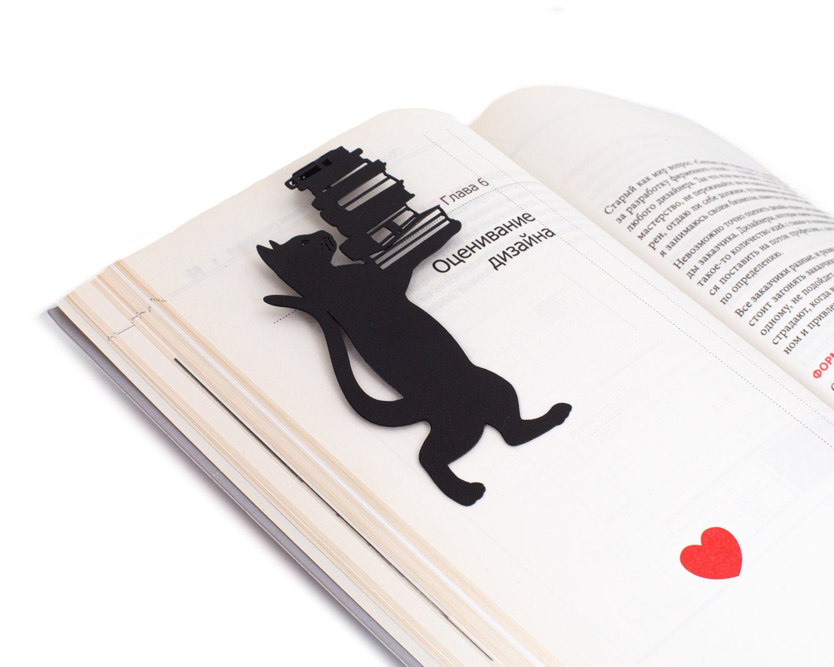 Cat the Librarian metal bookmark lying across the pages of an open book