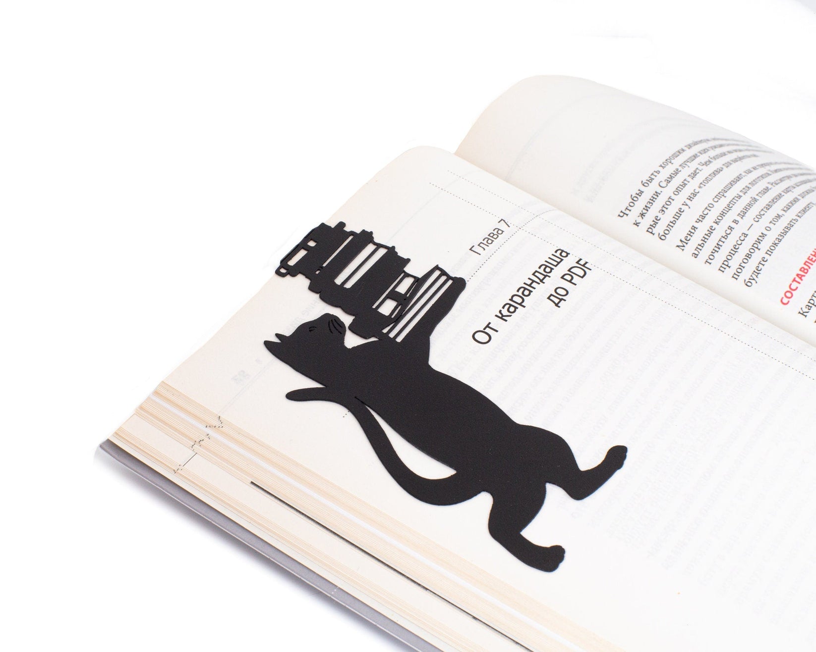 Cat the Librarian metal bookmark marking a page in an open book