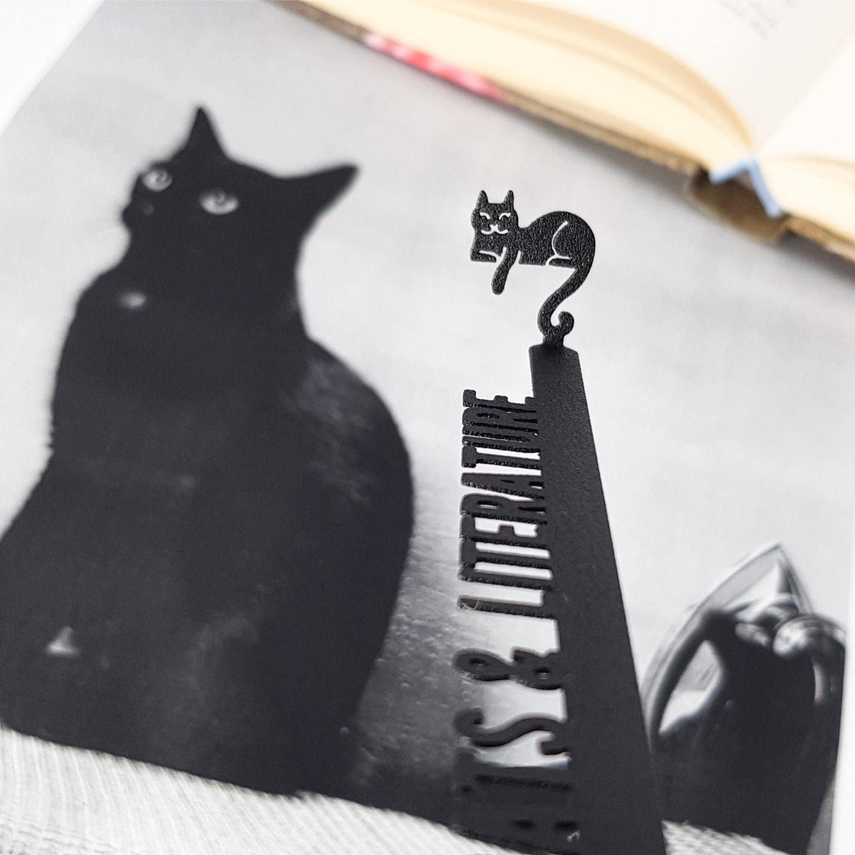 Cats and Literature metal bookmark on an illustrated page