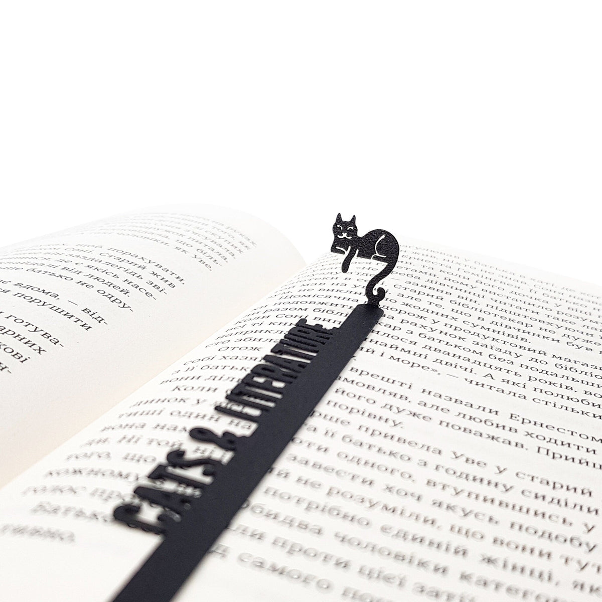 Cats and Literature metal bookmark marking a page in an open book