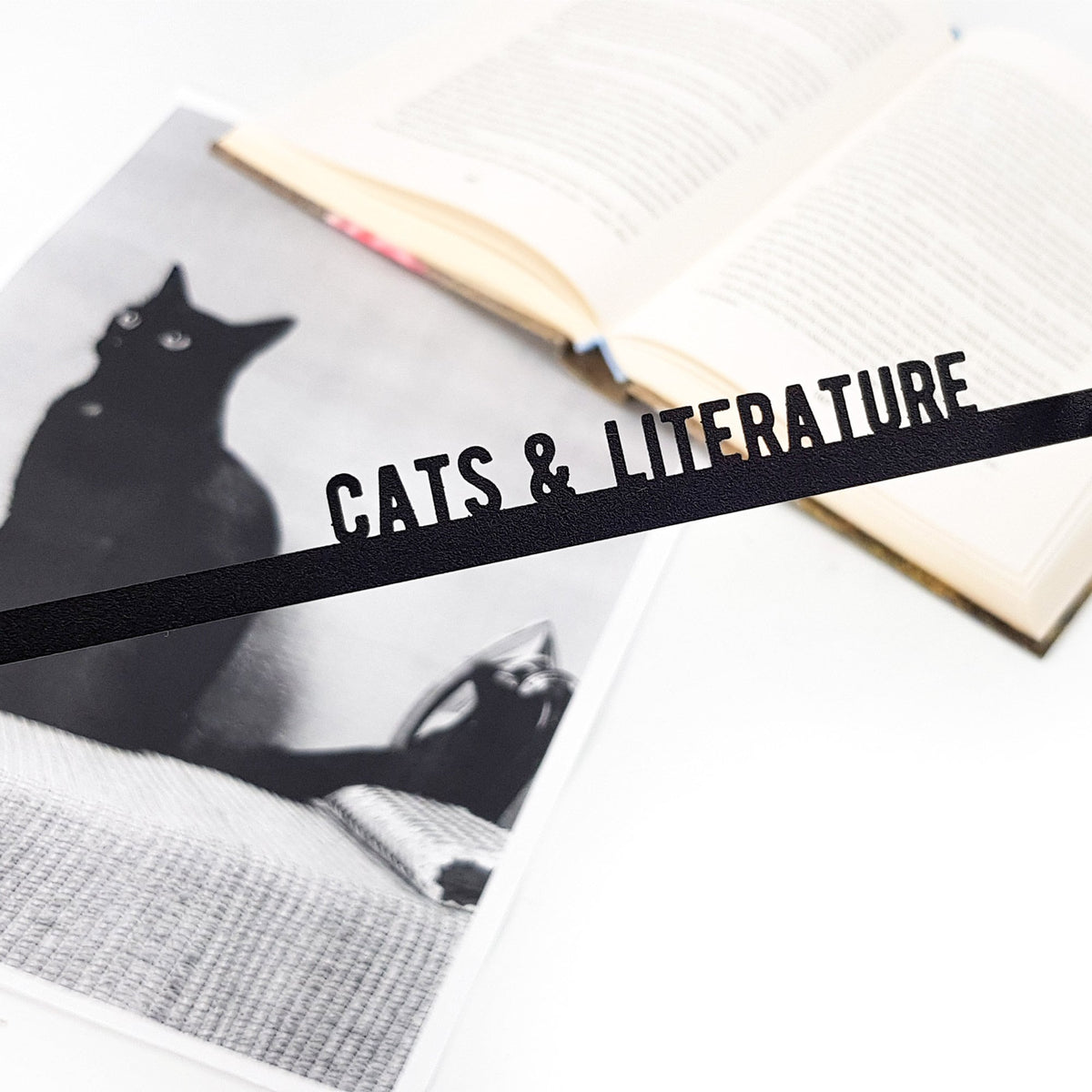 Cats and Literature metal bookmark placed on a colour illustration