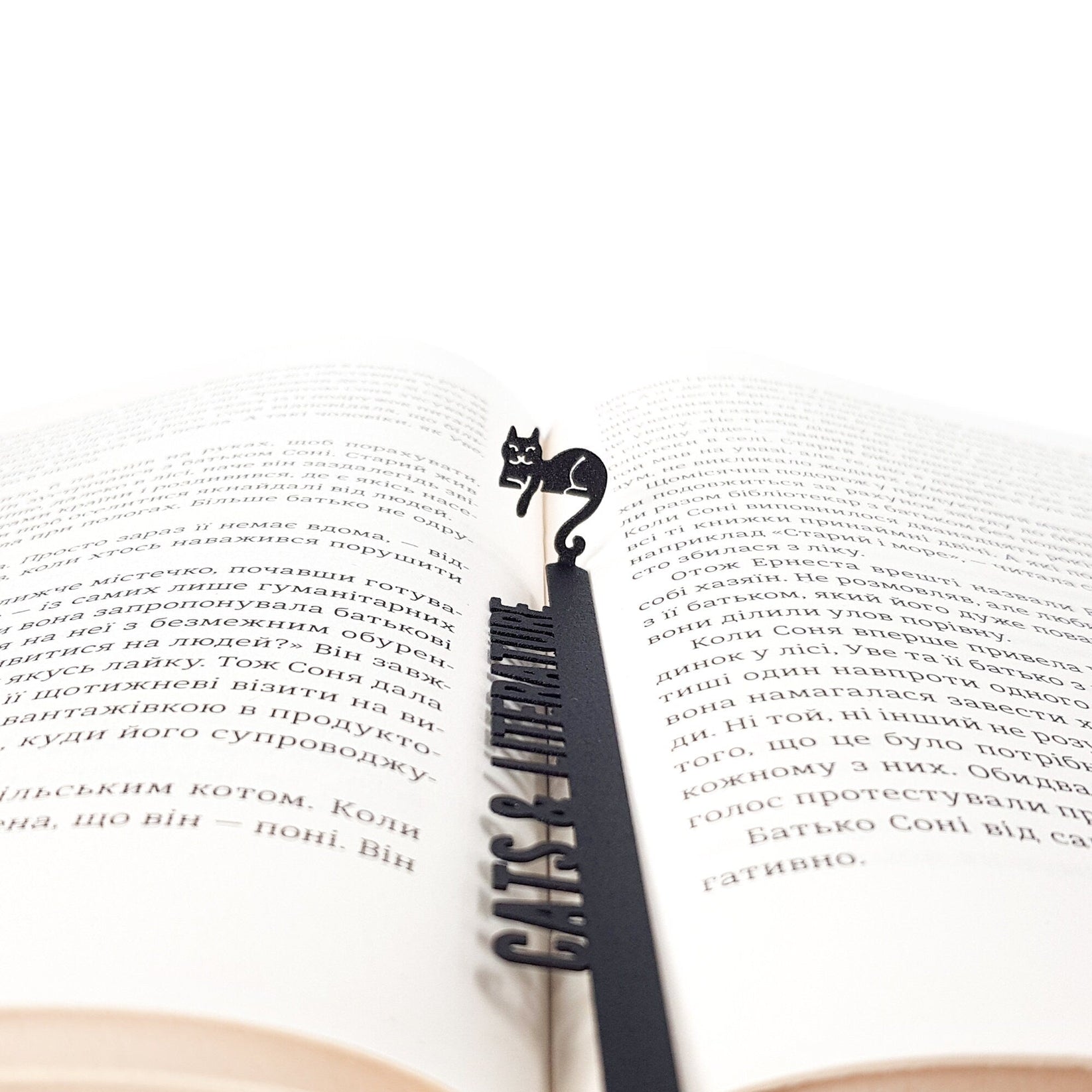 Cats and Literature metal bookmark set into the gutter of an open book