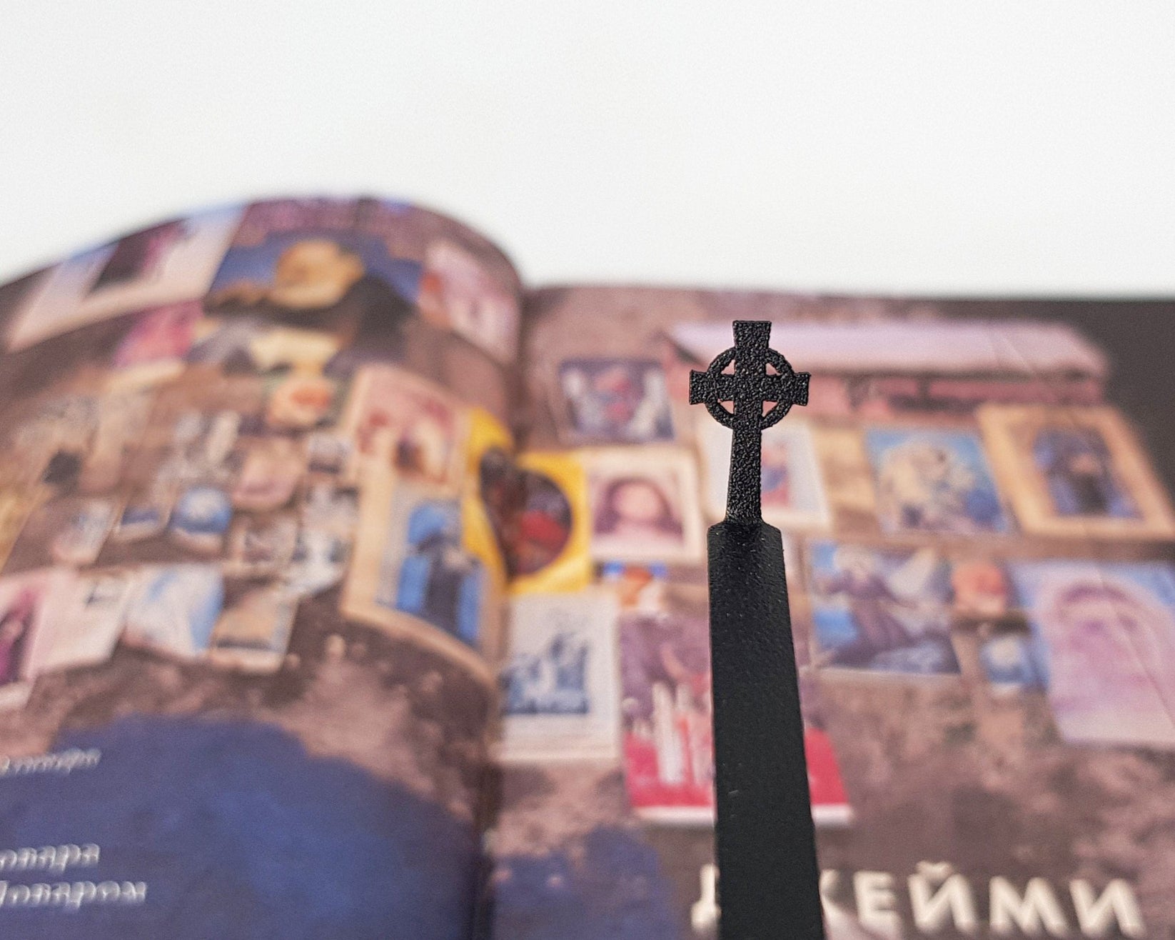 Celtic Cross metal bookmark marking a page in an illustrated book